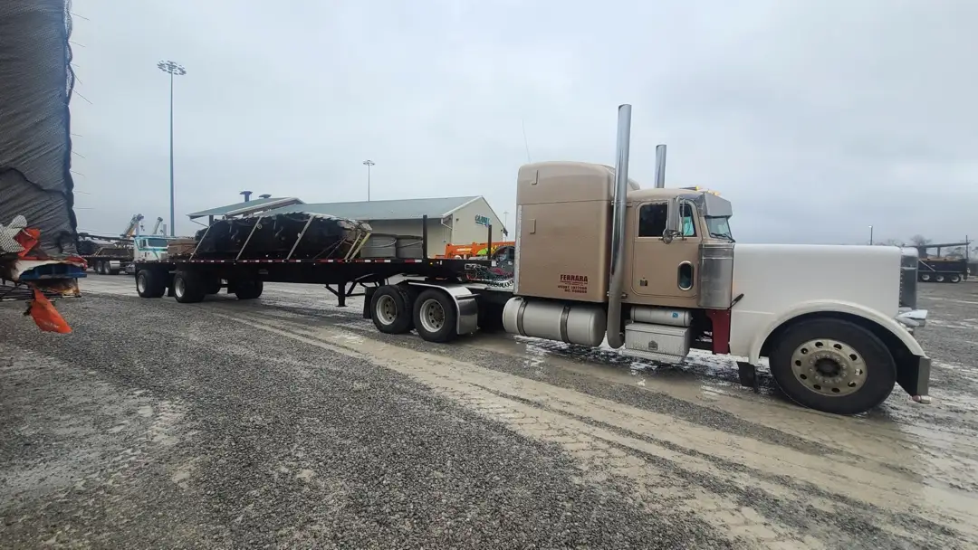 ferrara transport services flatbed hauling white semi in plant parking lot